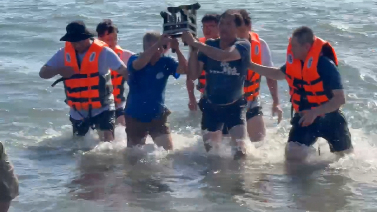 Una procesión religiosa se sumerge en el mar por el Festival del Bote del Dragón